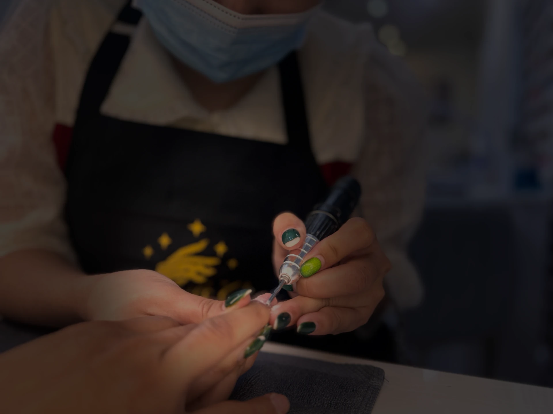 Background Image of Emmy Nails's owner who is also a nail technician performing a cuticle service